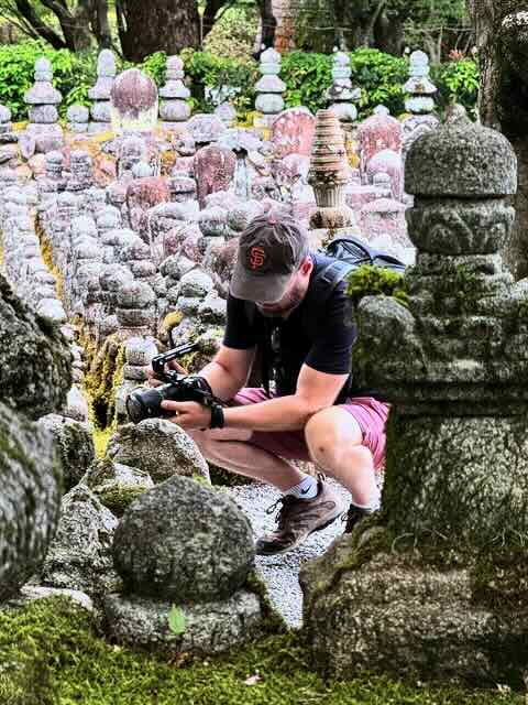 Damien July, vidéaste HorsChamp, en tournage parmi des statues de pierre